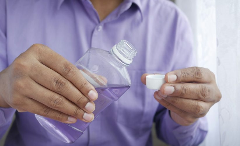person holding white plastic bottle